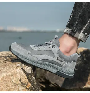 Outdoor close-up of breathable grey leather and mesh sneakers on rocky terrain