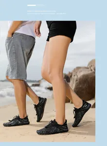 Nahaufnahme schwarzer Barfußschuhe mit Schnellverschlusssystem am sonnigen Strand