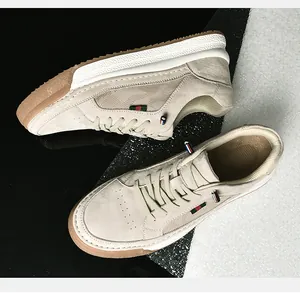 Detailed top view of men's suede sneakers with textured gum sole and striped side ribbon