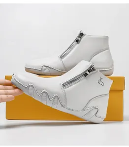 Detail of white leather boots with wave-textured anti-slip sole and side zipper
