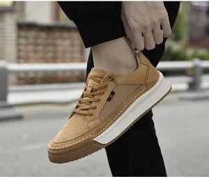 On-foot view of camel suede men's sneakers with thick white soles in an outdoor setting