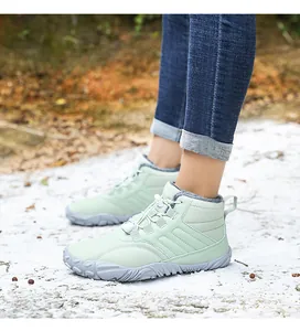 Detail of light green snow boots featuring non-slip rubber soles and warm plush lining
