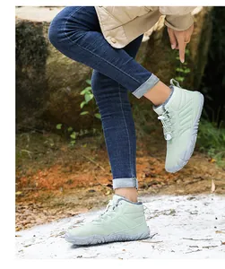 Close-up of light green winter boots with thick gray fleece lining and drawstring laces
