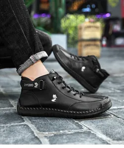 Detail der Handnähte an schwarzen Leder-Stiefeletten mit weißem Fuchs-Logo für Herren