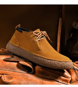 Macro shot of men's suede desert boots with textured rubber sole on leather background