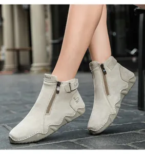 Close-up of women's warm grey nubuck leather boots with side zipper and buckle detail