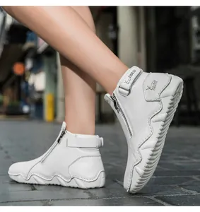 Detail of white leather boots with side zipper, velcro strap and non-slip wavy sole