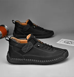 Dettaglio di stivali in pelle nera con cuciture a contrasto e cinturino in velcro
