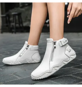 Detail of white leather boots featuring metal side zipper and branded velcro ankle strap