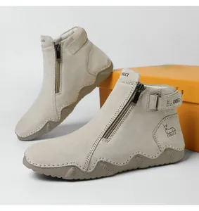 Detail view of leather boots featuring side zipper, buckle strap, and anti-slip rubber sole
