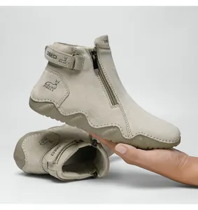 Detail of grey suede Martin boot featuring a side zipper and adjustable Velcro strap closure