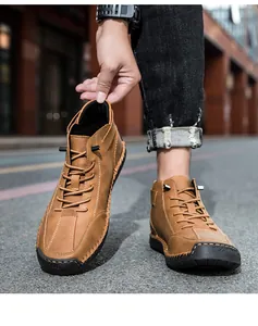 Detail of men's brown leather mid-top boots with hand-stitched seams and rubber soles