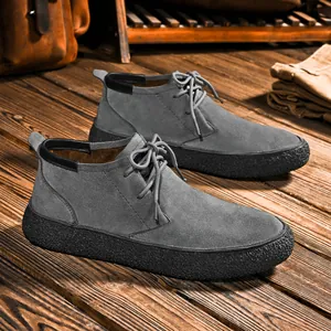 Men's dark grey suede chukka boots with chunky black rubber sole and retro industrial style