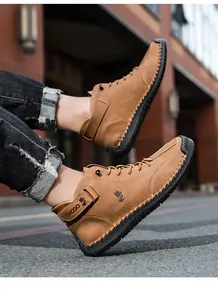 Detail shot of men's brown high-top casual shoes featuring white stitching and branding