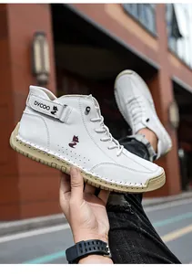 Detailed close-up of white high-top leather shoes showing hand-stitched soles and fox logo