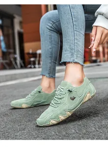 Nahaufnahme hellgrüner Wildleder-Freizeitschuhe mit Ziegen-Logo und Gummisohle