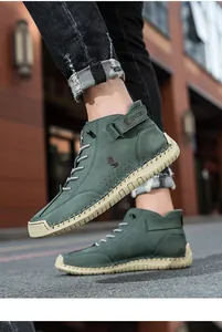 Detail of high-top green suede men's boot with hook-and-loop strap and fox logo