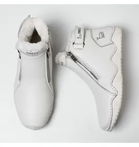 Detailed view of warm white leather boots featuring plush faux fur lining and side zipper
