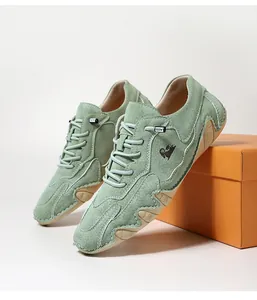 Detailansicht mintgrüner Wildleder-Freizeitschuhe mit weißer Naht und Ziegenlogo