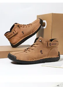 Detail of men's brown high-top leather boots with stitching and side fox logo