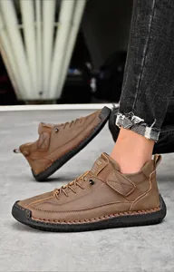 Dettagli di stivali da uomo in pelle marrone con cuciture spesse e chiusura velcro