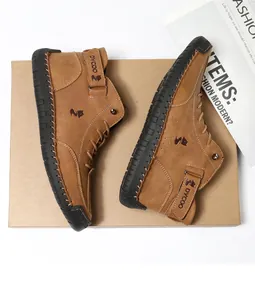 Detail of high-top brown leather boots featuring adjustable velcro strap and side stitching