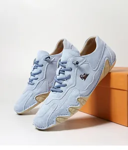 Detailansicht hellblauer Wildleder-Freizeitschuhe mit gelber Gummisohle und Logo