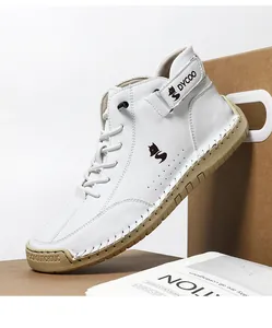 Detailed stitching on white high-top sneakers with gum rubber soles and brand logo