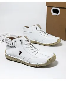 Detailed close-up of white high-top leather sneakers featuring hand-stitched seams and logo