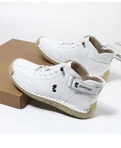 Detail of white high-top sneaker showing lychee grain leather and hand-stitched rubber sole