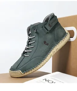 Detail shot of green suede high-top boots featuring a leather strap and fox logo