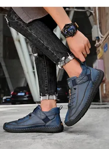 Dettaglio di stivali in pelle blu-grigio con cuciture a mano e cinturini in velcro