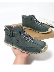 Detail of grey-green suede high-top shoe with durable stitched rubber sole and fox logo