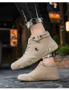 Detail shot of men's beige suede high-top boot with purple fox logo and wave-textured sole