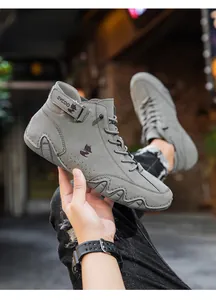 Close-up of grey high-top sneakers showing suede texture and velcro strap details