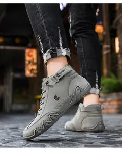 Detail of high-top outdoor sneakers in grey suede with lace-up and velcro strap