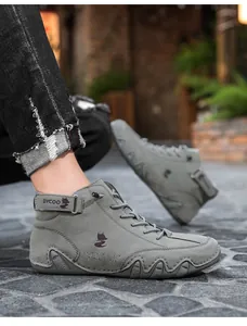 Detail of high-top sneakers showing grey suede texture, Velcro strap, and non-slip sole