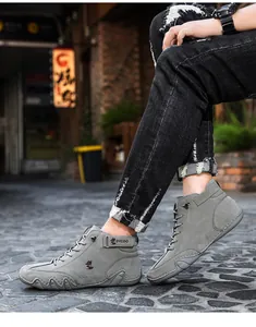 Macro detail of high-top grey suede boots featuring ankle strap and textured rubber sole