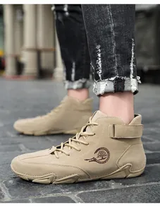 Détail de bottines montantes en daim kaki avec boucle décorative et semelle en caoutchouc