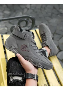 Détail d'une botte montante en nubuck gris avec bande velcro et logo tendance sur le côté