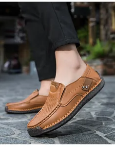 Dettaglio di mocassini in pelle marrone con cuciture a mano e ritagli traspiranti sulla scarpa