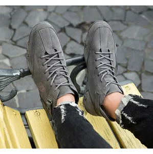 Détail des bottines grises en daim à semelles compensées avec lacets et boucle décorative