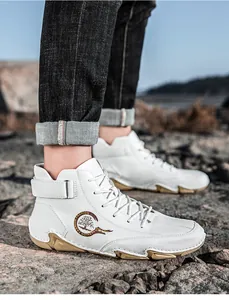 Nahaufnahme weißer Leder-High-Top-Schuhe mit Mode-Emblem auf einem felsigen Weg