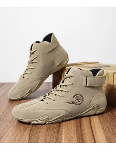 Détail de bottines de randonnée en daim kaki avec laçage et bride velcro à la cheville