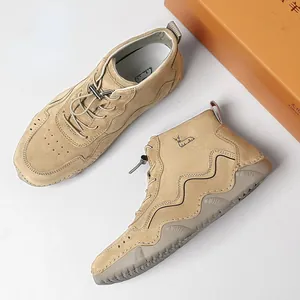 Nahaufnahme khakifarbener Wildlederstiefel mit Wellennähten und gesticktem Tier-Logo