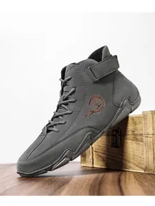 Vue détaillée de la botte en daim gris avec logo latéral et bride velcro de maintien