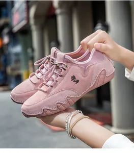Κοντινή λήψη ροζ σουέντ sneakers με λογότυπο αλεπού και μοναδική κυματιστή σόλα λεπτομέρεια