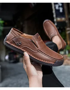Dettaglio del mocassino in pelle marrone con cuciture a mano e suola in gomma