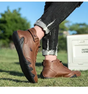 Outdoor shot showing side view of brown high-top leather boots with durable rubber soles