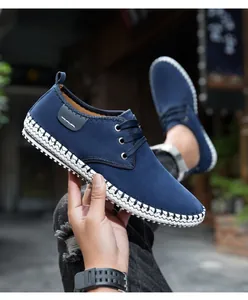 Detail of navy blue suede casual shoe with decorative white woven stitching on the sole